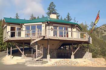 Pedestal Home in California with Green Metal Roof and Butterfly Flag
