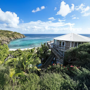 Aerial View | Hurricane-Resistant Topsider Home on St. John, US Virgin Islands Aerial view of two-story hurricane-resistant Topsider Home built into hillside on St. John, US Virgin Islands with pool and ocean views
