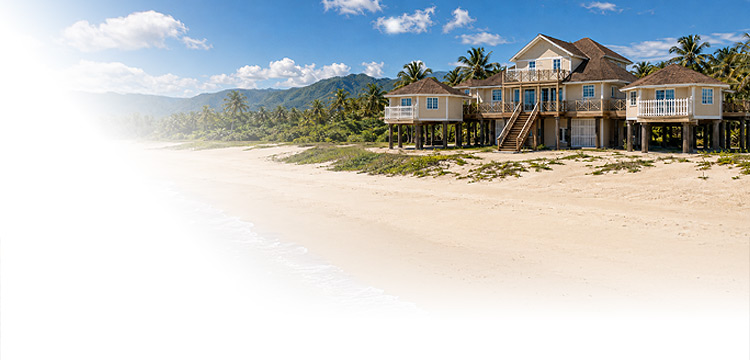 Elevated Topsider tropical beachfront prefab home in the South Pacific with palm trees and mountains