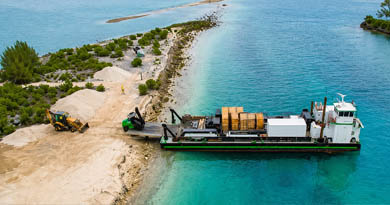 Barge delivering building materials to a remote Caribbean tropical building site