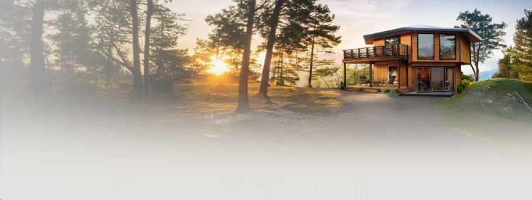 Modern two-story multi-sided home with expansive windows and wrap deck in a wooded setting — panelized, post-and-beam construction that maximizes light, views, and design flexibility.