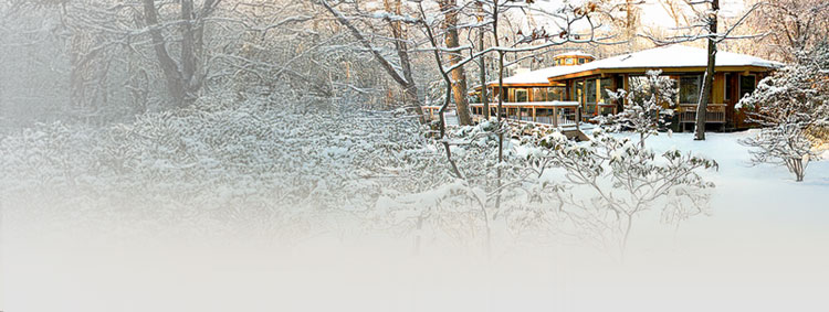 Topsider octagon home in upstate New York surrounded by snow with a wraparound porch with wide-angle views.