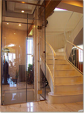 Topsider's post & beam building system allows Universal Design flexibility, like this attractive elevator and sweeping stairway combination.