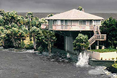 Topsider hurricane-resistant coastal Florida pedestal home surviving storm surge and waves during tropical storm or hurricane, elevated design for flood and wind protection with lush palm trees, oceanfront views, and sturdy construction.